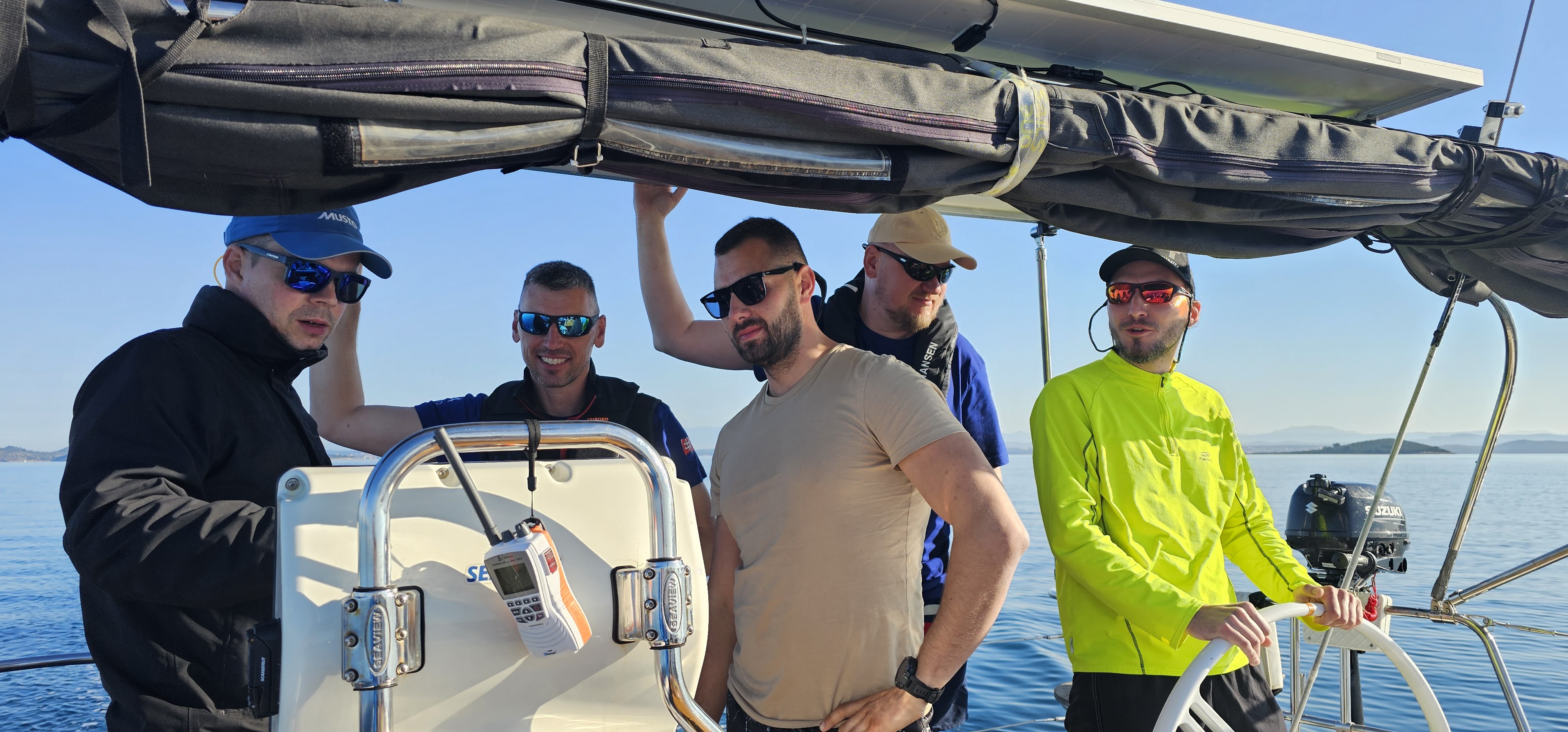 Skupina muzov riadi plachetnicu pocas jachtovania